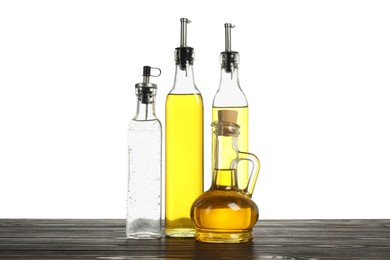 Photo of Salad dressings on wooden table against white background