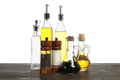 Photo of Salad dressings and spices on wooden table against white background