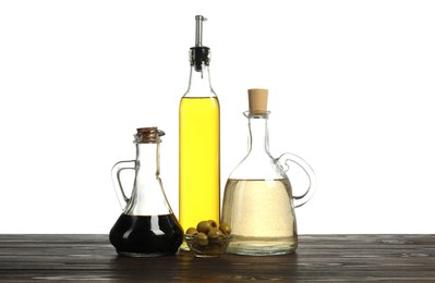 Photo of Salad dressings and olives on wooden table against white background