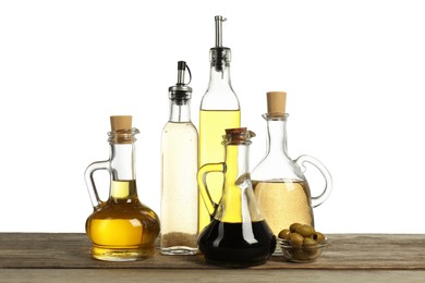 Photo of Salad dressings and olives on wooden table against white background