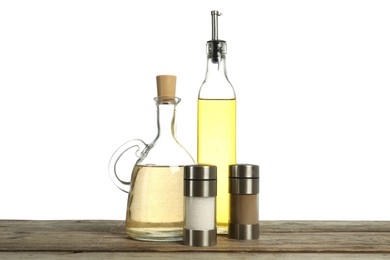 Photo of Salad dressings and spices on wooden table against white background