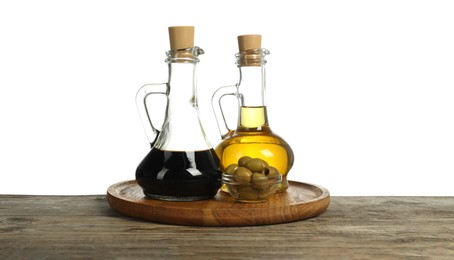 Photo of Salad dressings and olives on wooden table against white background