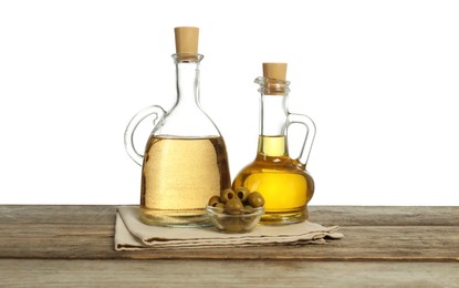 Photo of Salad dressings and olives on wooden table against white background