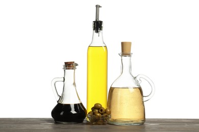 Photo of Salad dressings and olives on wooden table against white background