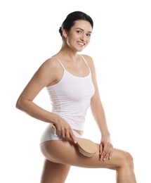 Woman doing anti cellulite massage with brush on white background