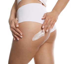 Photo of Woman applying anti cellulite cream on white background, closeup