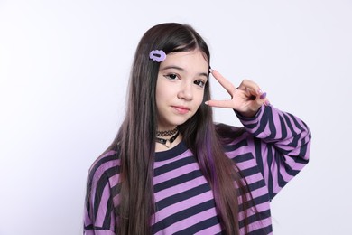 Photo of Teenage girl showing three fingers on white background. Makeup in anime style