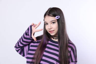 Teenage girl showing three fingers on white background. Makeup in anime style