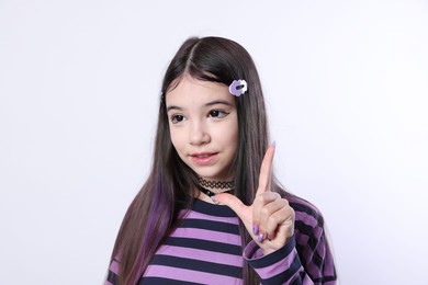 Photo of Teenage girl in stylish clothes and accessories posing on white background. Makeup in anime style