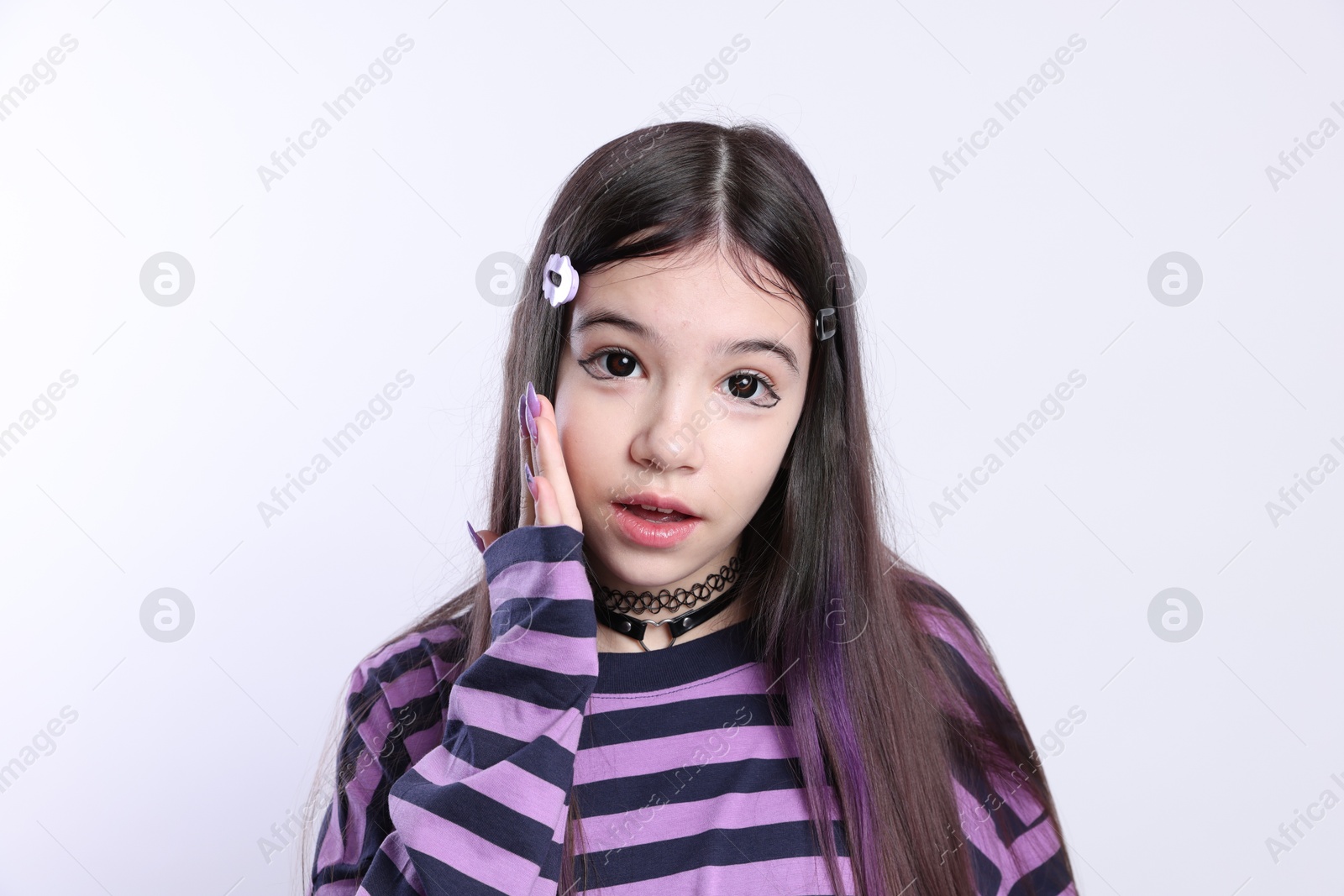 Photo of Teenage girl in stylish clothes and accessories posing on white background. Makeup in anime style