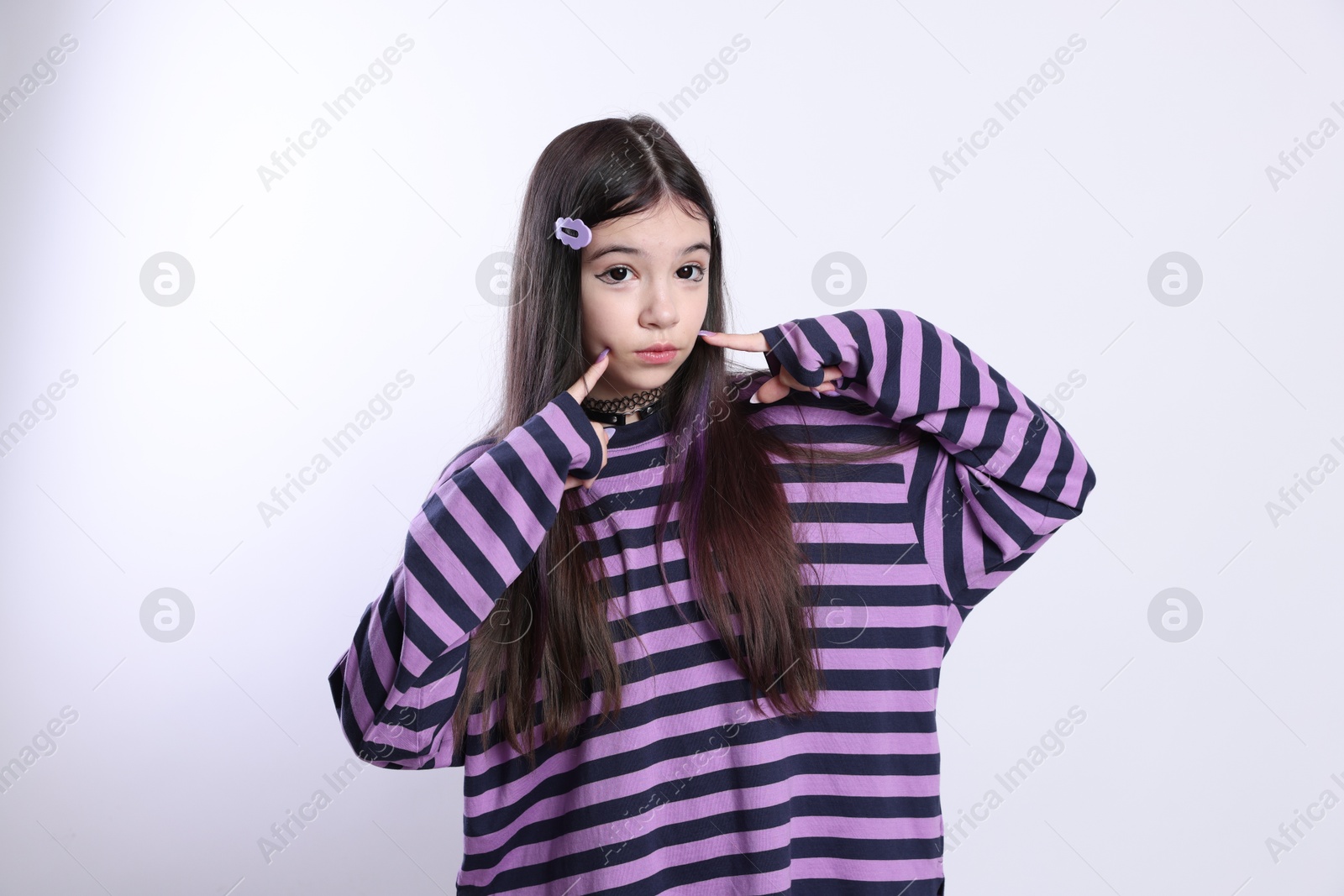 Photo of Teenage girl in stylish clothes and accessories posing on white background. Makeup in anime style