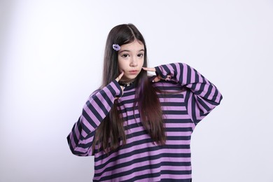 Teenage girl in stylish clothes and accessories posing on white background. Makeup in anime style