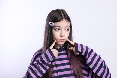 Teenage girl in stylish clothes and accessories posing on white background. Makeup in anime style