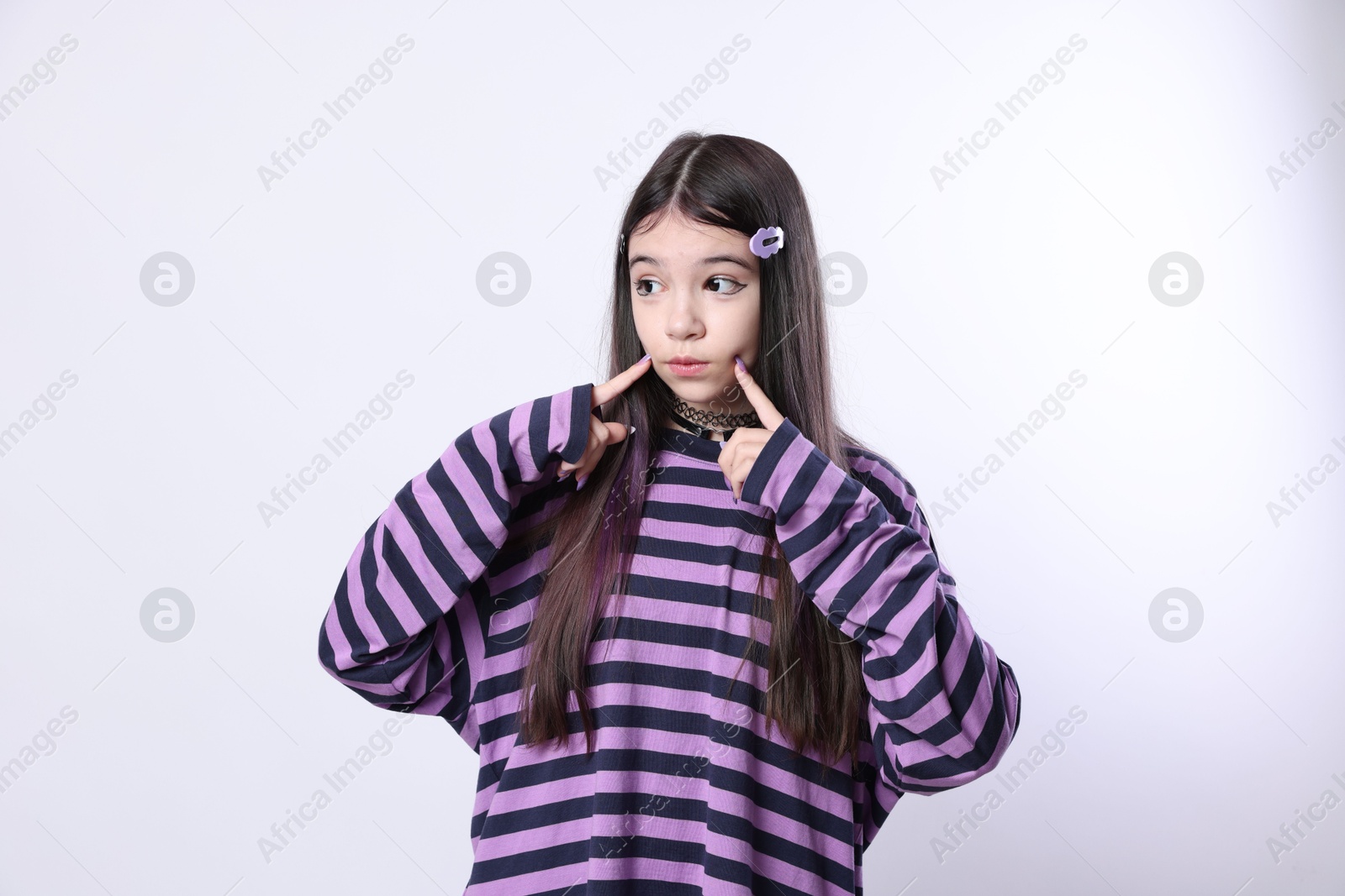 Photo of Teenage girl in stylish clothes and accessories posing on white background. Makeup in anime style