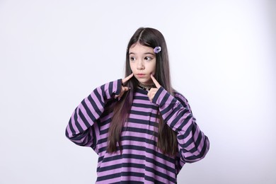 Teenage girl in stylish clothes and accessories posing on white background. Makeup in anime style