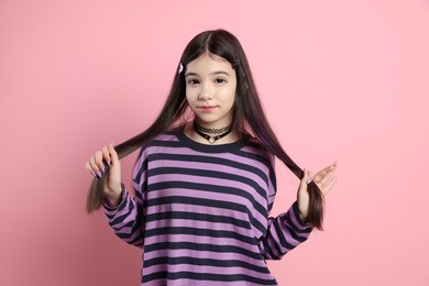 Photo of Teenage girl in stylish clothes posing on pink background. Makeup in anime style