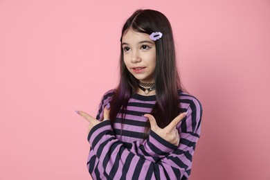 Photo of Teenage girl in stylish clothes posing on pink background. Makeup in anime style