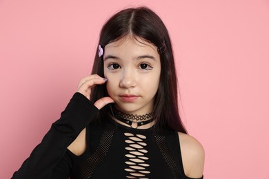 Photo of Teenage girl posing on pink background. Makeup and clothes in anime style