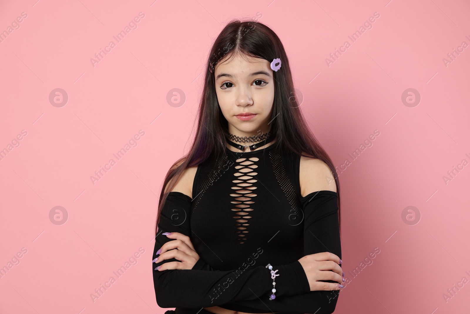 Photo of Teenage girl posing on pink background. Makeup and clothes in anime style