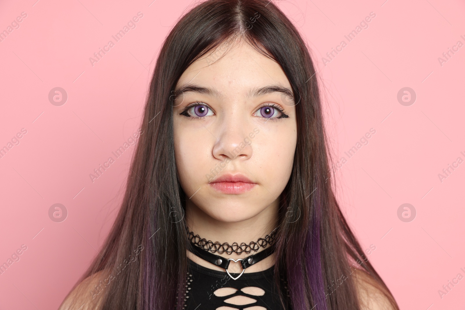 Photo of Teenage girl posing on pink background. Makeup and clothes in anime style