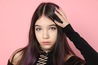 Photo of Teenage girl posing on pink background. Makeup and clothes in anime style