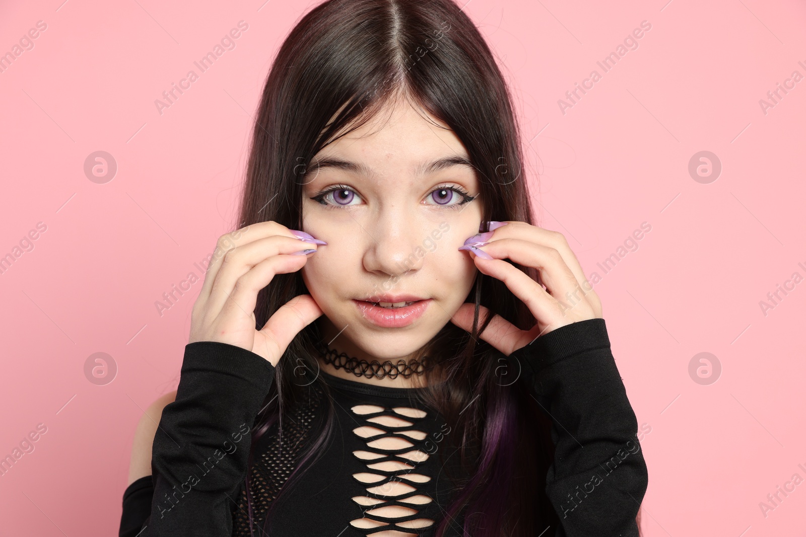 Photo of Teenage girl posing on pink background. Makeup and clothes in anime style