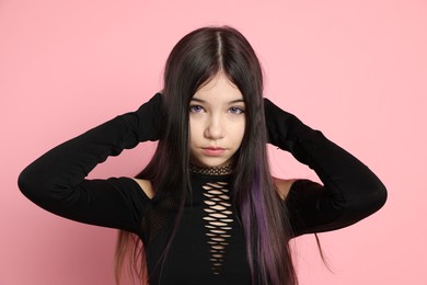 Photo of Teenage girl posing on pink background. Makeup and clothes in anime style