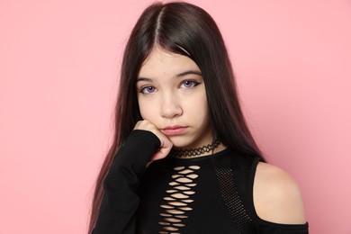 Photo of Teenage girl posing on pink background. Makeup and clothes in anime style