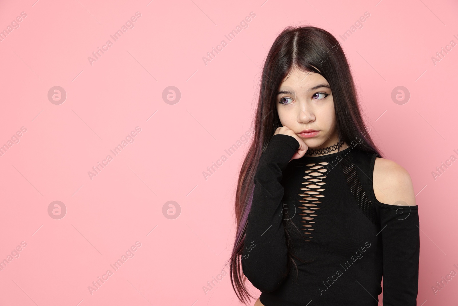 Photo of Teenage girl posing on pink background, space for text. Makeup and clothes in anime style