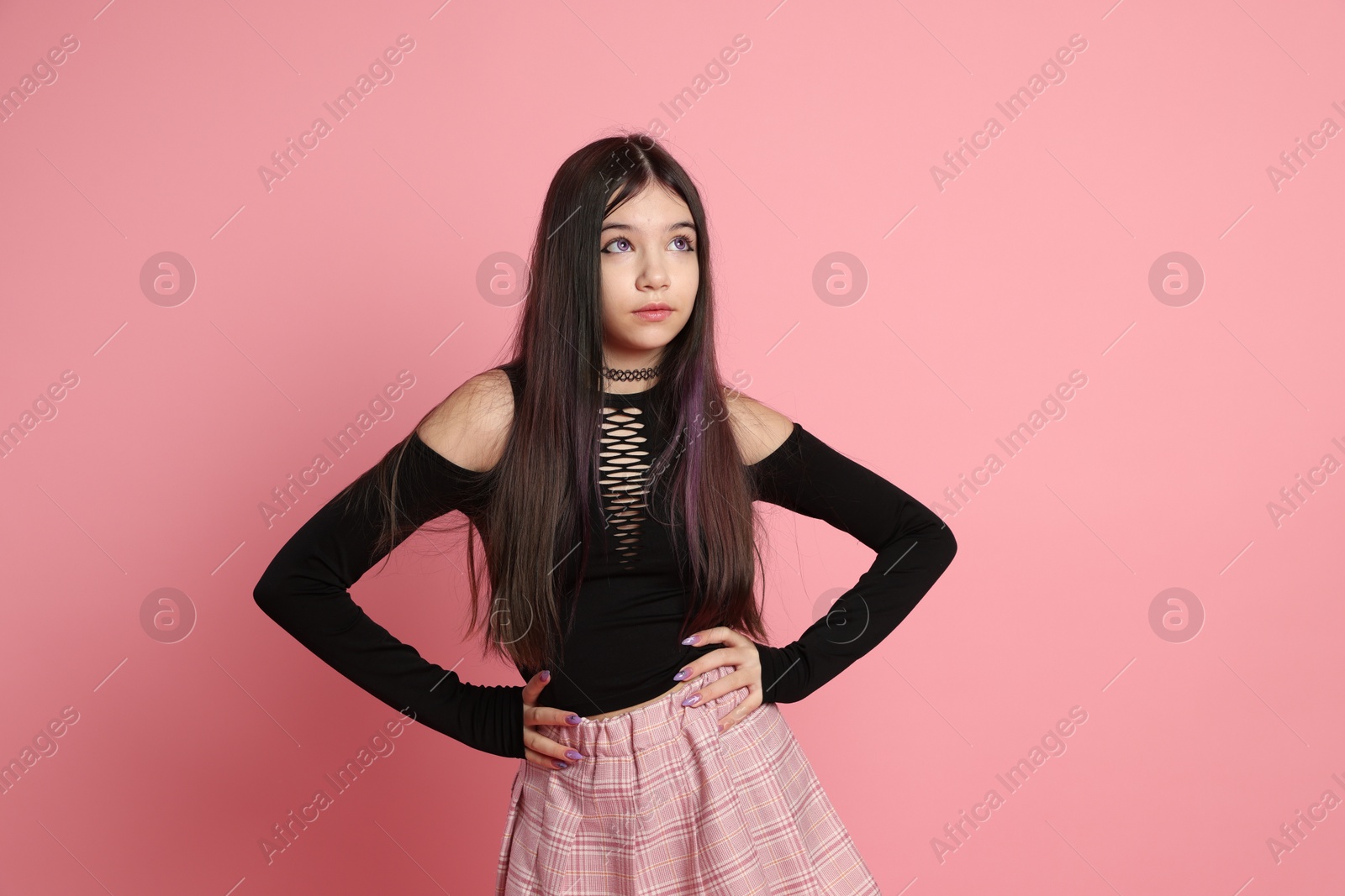 Photo of Teenage girl posing on pink background. Makeup and clothes in anime style