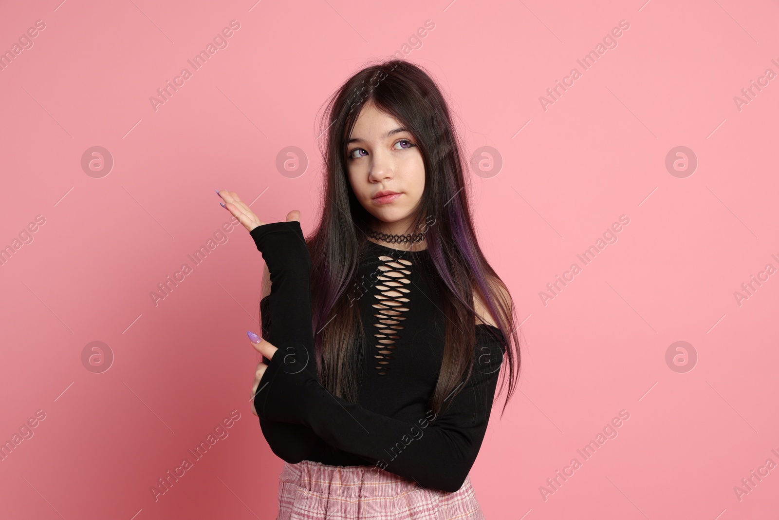 Photo of Teenage girl posing on pink background. Makeup and clothes in anime style