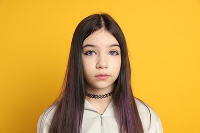 Teenage girl in stylish clothes posing on orange background. Makeup in anime style