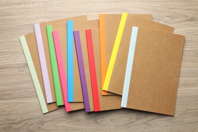 Photo of Different copybooks on wooden table, flat lay