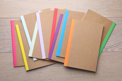 Photo of Different copybooks on wooden table, flat lay