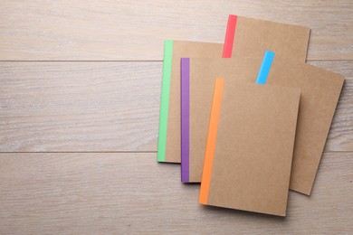 Photo of Different copybooks on wooden table, flat lay. Space for text