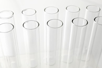 Photo of Empty test tubes on light background, closeup. Laboratory glassware