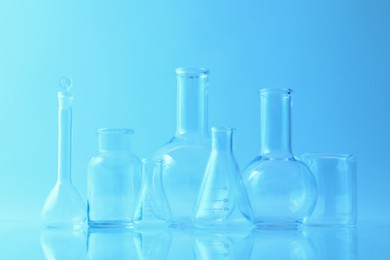 Different laboratory glassware on light blue background