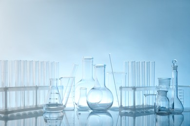 Photo of Laboratory glassware on mirror surface against light background