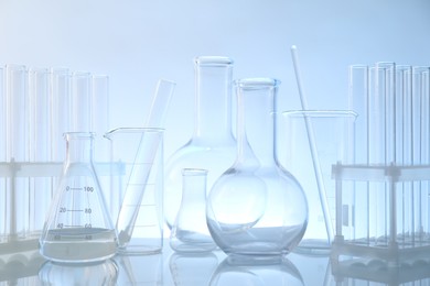 Laboratory glassware on mirror surface against light background