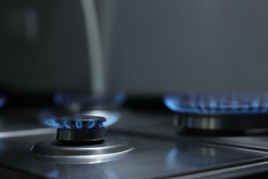 Gas burners with blue flame on stove, closeup