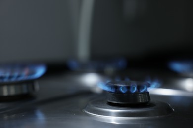 Photo of Gas burners with blue flame on stove, closeup