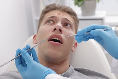 Scared man having appointment with dentist in clinic