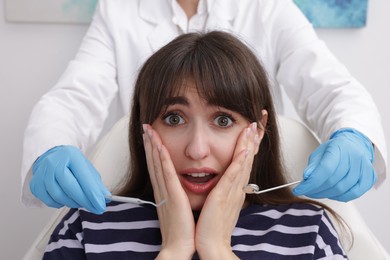 Scared woman having appointment with dentist in clinic