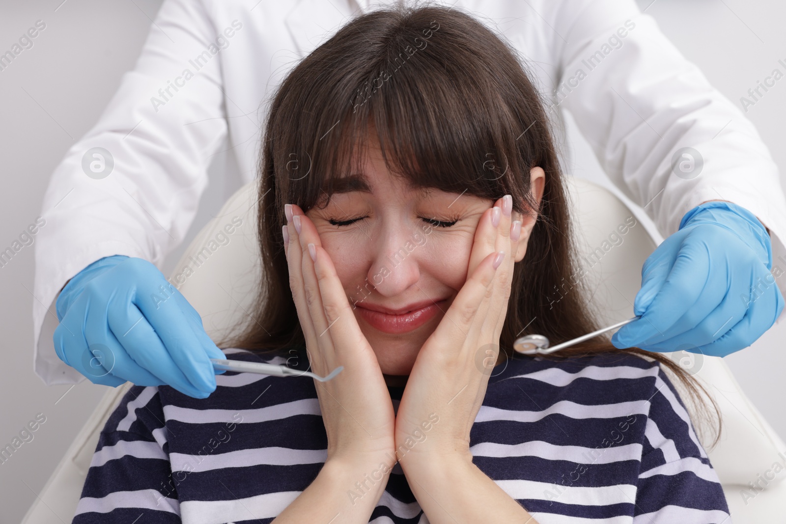 Photo of Scared woman having appointment with dentist in clinic