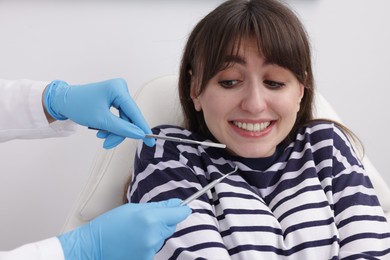 Photo of Scared woman having appointment with dentist in clinic