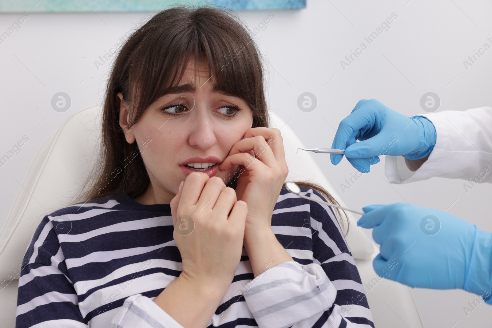 Photo of Scared woman having appointment with dentist in clinic