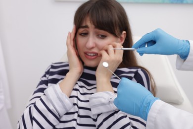 Scared woman having appointment with dentist in clinic