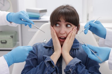 Scared woman having appointment with dentist and assistant in clinic