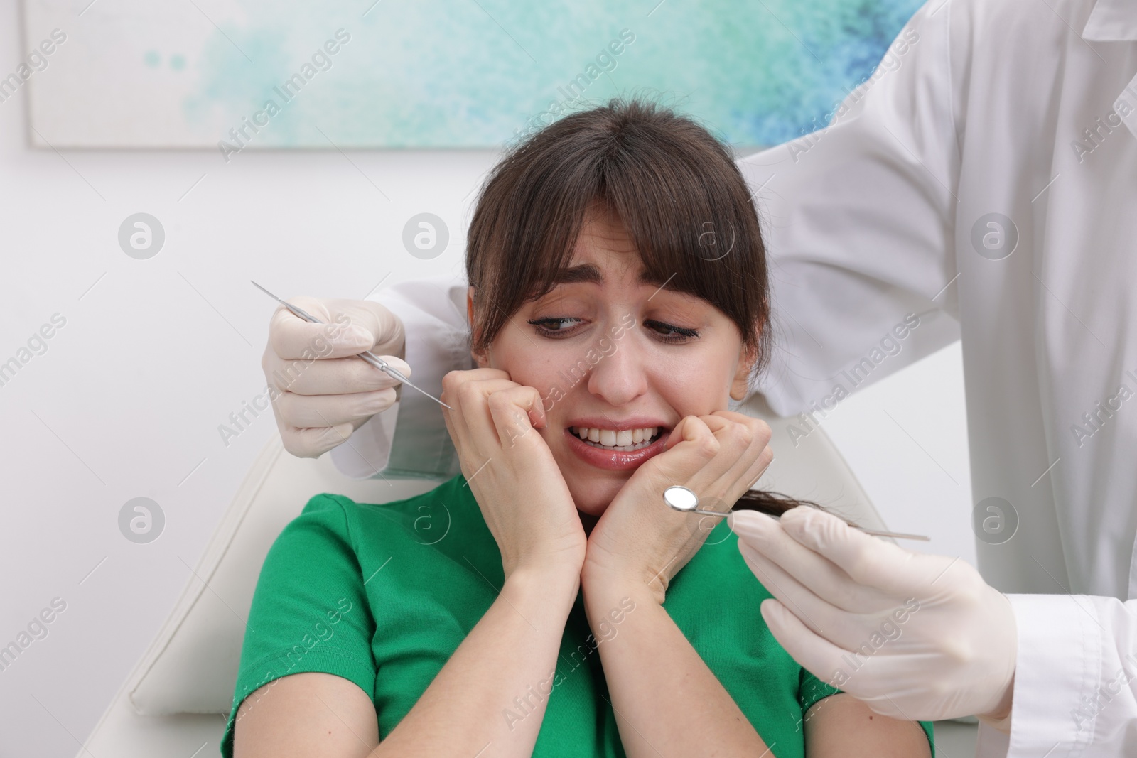 Photo of Scared woman having appointment with dentist in clinic