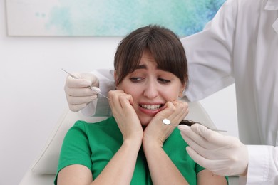 Scared woman having appointment with dentist in clinic